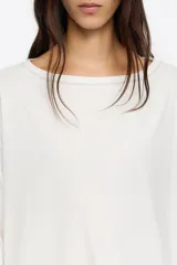 Vestido midi de corte holgado con diseño bimaterial. La parte superior simula una remera de manga larga en color negro, mientras que la falda presenta un estampado animal print en tonos marrones con bajo irregular y fluido.