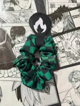 Scrunchie de tela sublimada con diseño a cuadros verdes y negros, inspirado en el personaje Tanjiro del anime Kimetsu no Yaiba.