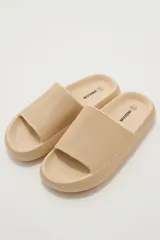 Sandalias tipo ojota de goma color tostado con suela chunky y textura en relieve en la tira superior.
