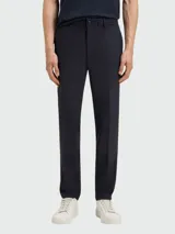 Pantalón de vestir azul oscuro, corte moderno, con pliegues marcados en el frente y cierre de botón.