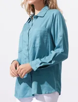 Camisa color verde oliva de lyocell, marca Cyrus. Tiene cuello con solapa, abertura central con botones, mangas 3/4 regulables con presilla y botón, y dos bolsillos delanteros aplicados.