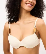 Top de bikini confeccionado en microfibra acanalada, de color beige con aros estructurados y breteles regulables con apliques decorativos ovalados.