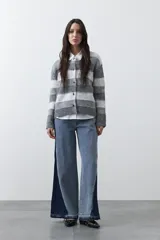 Cardigan de tejido suave con diseño de rayas horizontales en tonos marrones y beige, con cuello redondo y cierre frontal de botones.