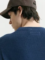 Sweater de punto inglés con escote redondo y mangas largas. Presenta cuello y puños terminados en punto canalé.