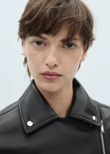 Chaqueta de diseño biker en efecto piel color negro, con solapas con muesca, cierre cruzado con cremallera y bolsillos laterales con cremallera.