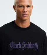 Remera negra de algodón con corte comfort, cuello redondo y manga corta. Presenta un estampado frontal con el logo de la banda Black Sabbath en color violeta.