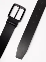 Cinturón de cuero negro con textura granulada, hebilla metálica rectangular en color negro mate y cierre de espiga.
