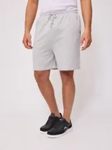 Bermuda deportiva gris confeccionada en 60% algodón y 40% poliéster, con cintura elástica ajustable con cordón.