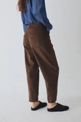 Pantalón de corte barrel en pana color azul marino, con cierre frontal de botones metálicos dorados a la vista y costuras reforzadas en las rodillas.