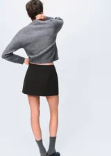 Chaqueta de punto grueso color gris, con cuello redondo, diseño recto, manga larga y cierre delantero con botones.