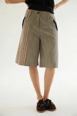 Bermuda de talle alto con diseño de rayas verticales combinadas en tonos beige y marrón, bolsillos laterales con detalles en negro y cierre frontal con botón.
