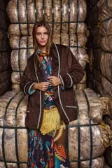 Blazer holgado de terciopelo marrón con cuello con solapa, sin cierre frontal y con tres bolsillos funcionales. Intervenido artesanalmente con detalles de tientos y pompones de algodón teñidos a mano. Forrado en las mangas con estampa the farra.