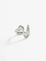 Anillo ajustable de acero quirúrgico hipoalergénico, con diseño orgánico e irregular que simula una ola o una forma abstracta.