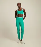 Conjunto deportivo verde esmeralda con detalles en blanco, compuesto por un top con tirantes y una calza larga de cintura alta.