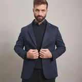 Saco de gabardina azul marino con solapa de muesca, dos botones frontales y bolsillos de parche.