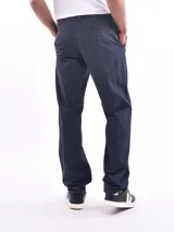 Pantalón de vestir azul oscuro, de corte recto, con bolsillos laterales y traseros. Se ajusta a la cintura con cinturón de cuero marrón.