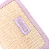 Billetera Extra Large modelo Joan, con cierre perimetral, confeccionada con detalles en símil cuero lila y cuerpo de textura trenzada en tonos naturales, con placa metálica con el logo de la marca en el frente.