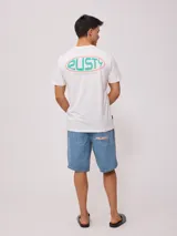 Remera blanca de algodón con logo ovalado de la marca Rusty estampado en el pecho.