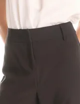 Pantalón sastrero de tiro alto y pierna ancha, con cierre frontal y gancho interno. Presenta bolsillos laterales de ojal y un diseño minimalista con caída fluida.