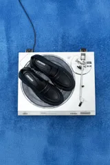 Mocasines negros de cuero vegano con suela track y detalle de antifaz.