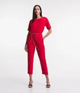 Pantalón zanahoria rojo de crepé con cintura alta, trabillas, pliegues, bolsillos y cinturón de cadena metalizada.