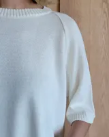 Buzo de punto color verde kiwi con cuello, puños y ruedo en azul.