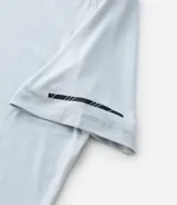 Remera deportiva de hombre con tecnología dry fit, cuello redondo y manga corta. Presenta un diseño liso en color beige con una pequeña etiqueta decorativa en el dobladillo.