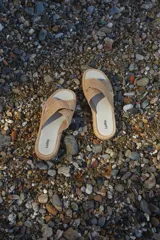 Sandalias bajas color beige con tiras cruzadas de yute y suela plana.