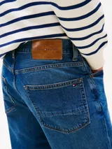 Pantalón de jean Tommy Hilfiger modelo Denton en color azul índigo medio, de corte recto y diseño clásico de cinco bolsillos, con cierre de botón y cremallera.