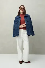 Top negro de manga corta tejido con textura acanalada, cuello alto y terminaciones onduladas.