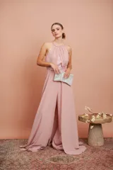 Enterito largo rosado con cuello halter, diseño drapeado en el torso con detalles de lentejuelas y pantalón amplio de estilo fluido.