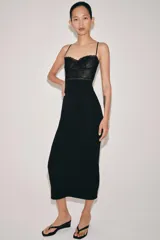 Vestido midi negro de tirantes finos, con corpiño estructurado y detalle de encaje negro en la parte superior.
