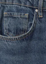 Jeans de tiro alto y corte flare, confeccionados en tejido de algodón estilo tejano vaquero. Presentan diseño de cinco bolsillos, trabillas para cinturón y cierre frontal con cremallera y botón.