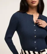 Cardigan corto celeste en punto con textura acanalada, cuello redondo, manga larga y abotonado delantero.