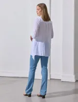 Camisa larga de rayón, con cuello camisero, cierre frontal de botones y mangas con presilla para regular el largo. Presenta un corte holgado con tajos laterales en el ruedo.