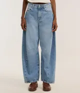 Pantalón de jeans celeste marmolado, corte barrel, con trabillas en la cintura, bolsillos delanteros y traseros, y detalle de recortes en las rodillas.