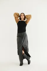 Falda larga tipo cargo de eco cuero color negro, con tajo frontal pronunciado y bolsillos utilitarios a los costados.