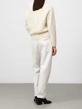 Sweater de punto con cuello en V, manga larga y diseño holgado. Presenta puños y ruedo en tejido acanalado, confeccionado en una mezcla de lana merino y alpaca.
