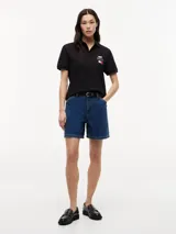 Chomba de algodón elástico con cuello polo y cartera de tres botones. Presenta un diseño de corte regular con cuello y puños de punto canalé, destacando por el logo colaborativo de Tommy Hilfiger y Cadillac Formula 1 en el pecho.