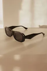 Lentes de sol con diseño estructurado, líneas limpias y frente recto en color negro.