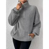 Buzo de polar con textura suave, color beige, con cuello alto y cierre frontal parcial. Diseño de manga larga y calce holgado.