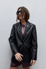 Blazer de cuero sintético negro con solapas clásicas, cierre de un botón y bolsillos frontales con solapa.