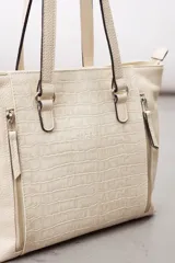 Cartera de cuero vacuno color marrón, de diseño amplio con paneles combinados de diferentes texturas y un panel central con relieve de cocodrilo. Cuenta con cierre frontal vertical y asas de hombro.