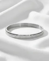 Pulsera tipo esclava rígida de acero inoxidable con diseño grabado de números romanos en toda su superficie.