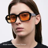 Lentes de sol rectangulares unisex, con montura fina negra y lentes color naranja.