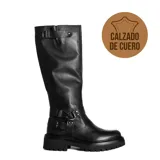 Bota de caña alta confeccionada en cuero negro, con suela track robusta y detalle de correas con hebillas metálicas y tachas en la zona del tobillo y en la parte superior de la caña.