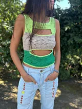 Top tejido a crochet sin mangas con diseño de bloques de color en verde lima, beige y verde esmeralda, presentando aberturas estratégicas en el frente.