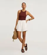 Blusa sin mangas de corte regular, confeccionada en tejido rib de algodón con cuello redondo. Presenta un diseño minimalista y anatómico, ideal para un look clásico.