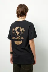 Remera negra de corte oversize con cuello redondo y manga corta. Presenta un pequeño estampado dorado en el pecho con la frase "love earth" y un símbolo de hojas.