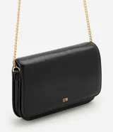 Cartera bandolera Satinato de tamaño pequeño, confeccionada en poliuretano color negro con efecto texturizado. Cuenta con solapa frontal, herrajes y correa larga de cadena dorada, además del logo metálico de la marca en la parte inferior.